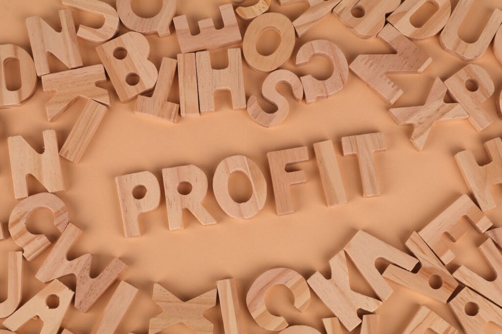 Wooden letters scattered on a table with 'PROFIT' prominently displayed.